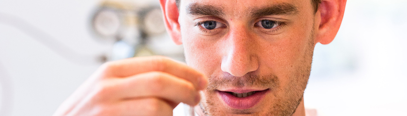 A male researcher examining a sample during an experiment