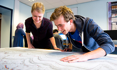 Two researchers looking down at a map