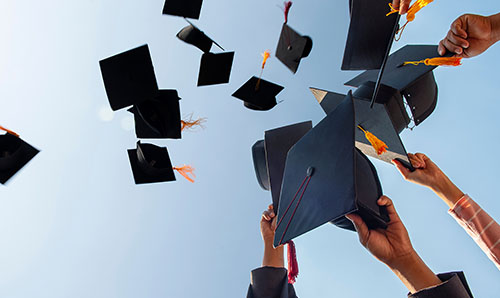 Graduating students throwing their caps into the air