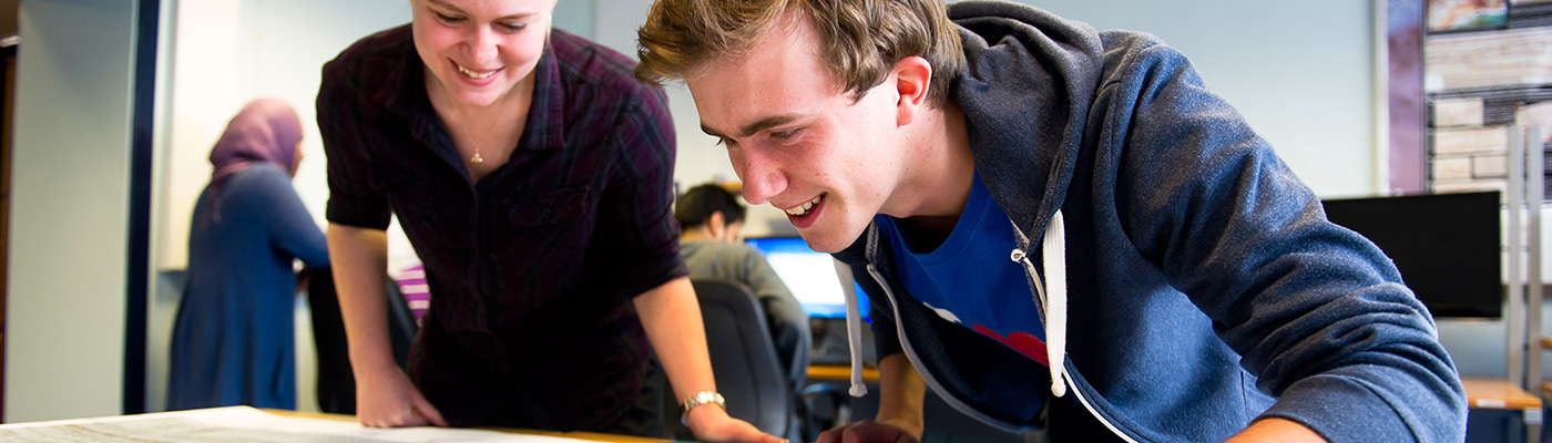 Two researchers looking down at a map