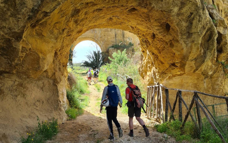 A group of students walking through rock formations in Sicily
