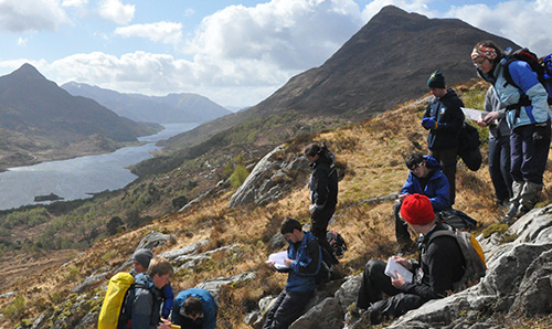 Students on a field trip at the foot of a mountain