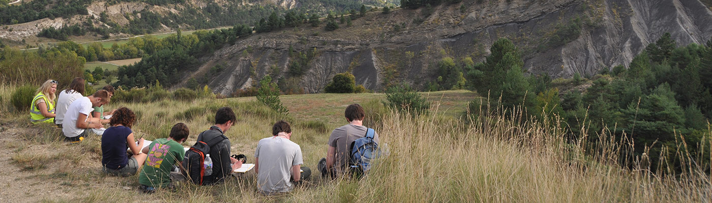 A group of students looking out and taking notes while on a field trip