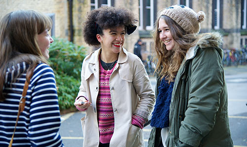 Three female students chatting and laughing together