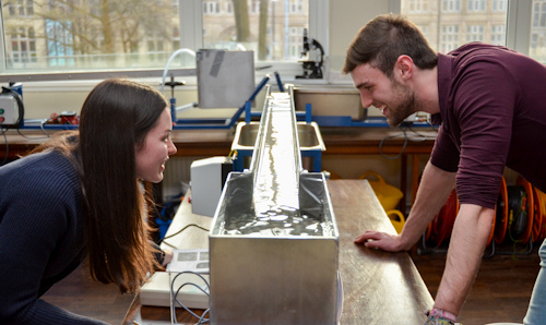 Two students using water flow monitoring equipment